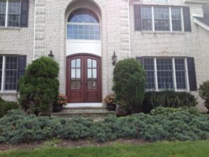 A curbside view of a grand home with a stunning wood door