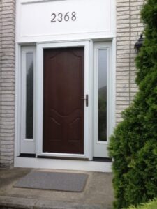 A stunning, dark fiberglass entry door installed by Kennedy Windows & Doors 